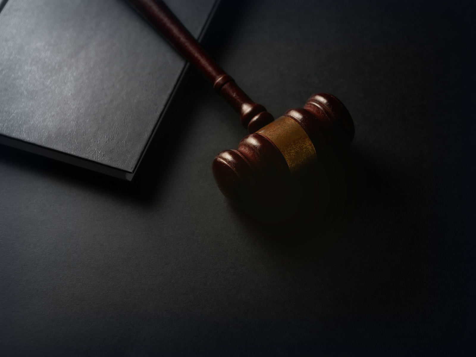 Gavel and legal book on a dark law office desk